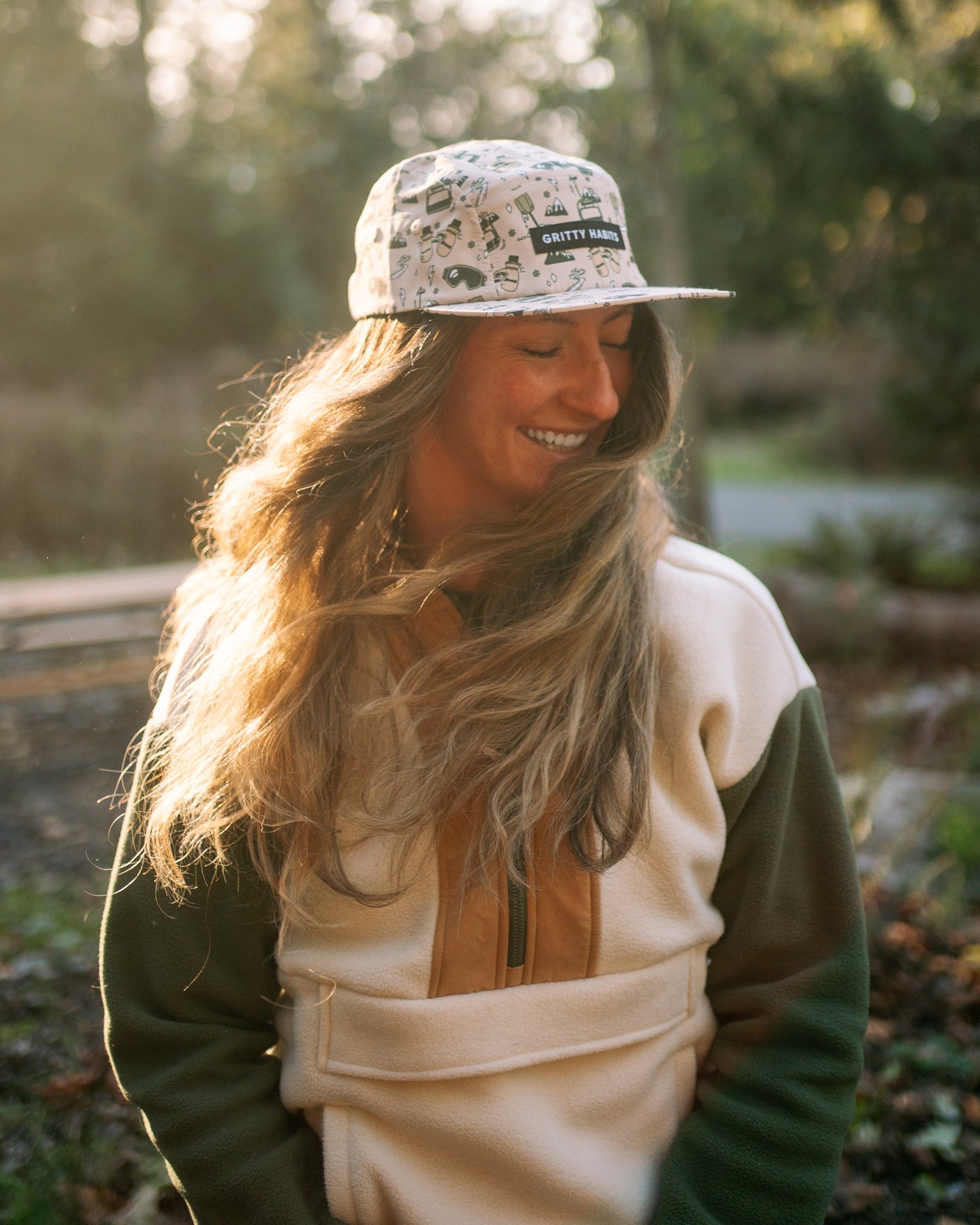 Person wearing a cap and a jacket with a forest background